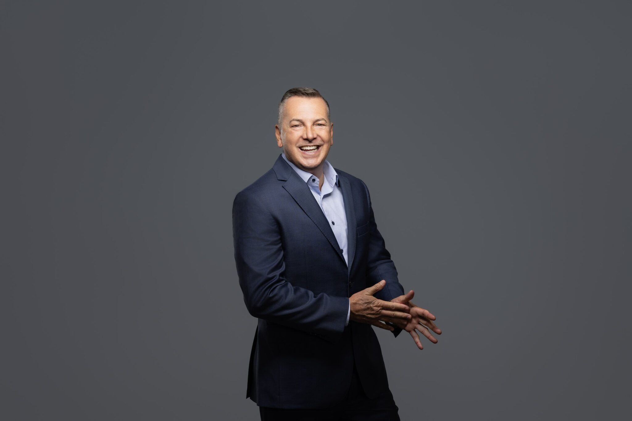 Business franchisee owner headshot in front of grey background.